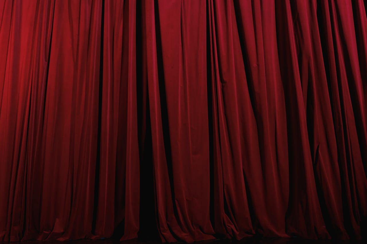 Rich red curtains with elegant drapery, perfect for theater or luxury decor themes.